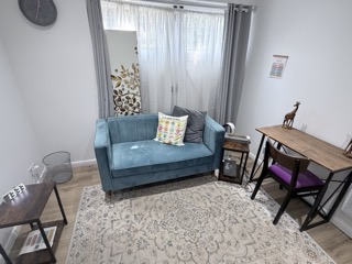 Photo of the counselling room sofa and desk for drawing.